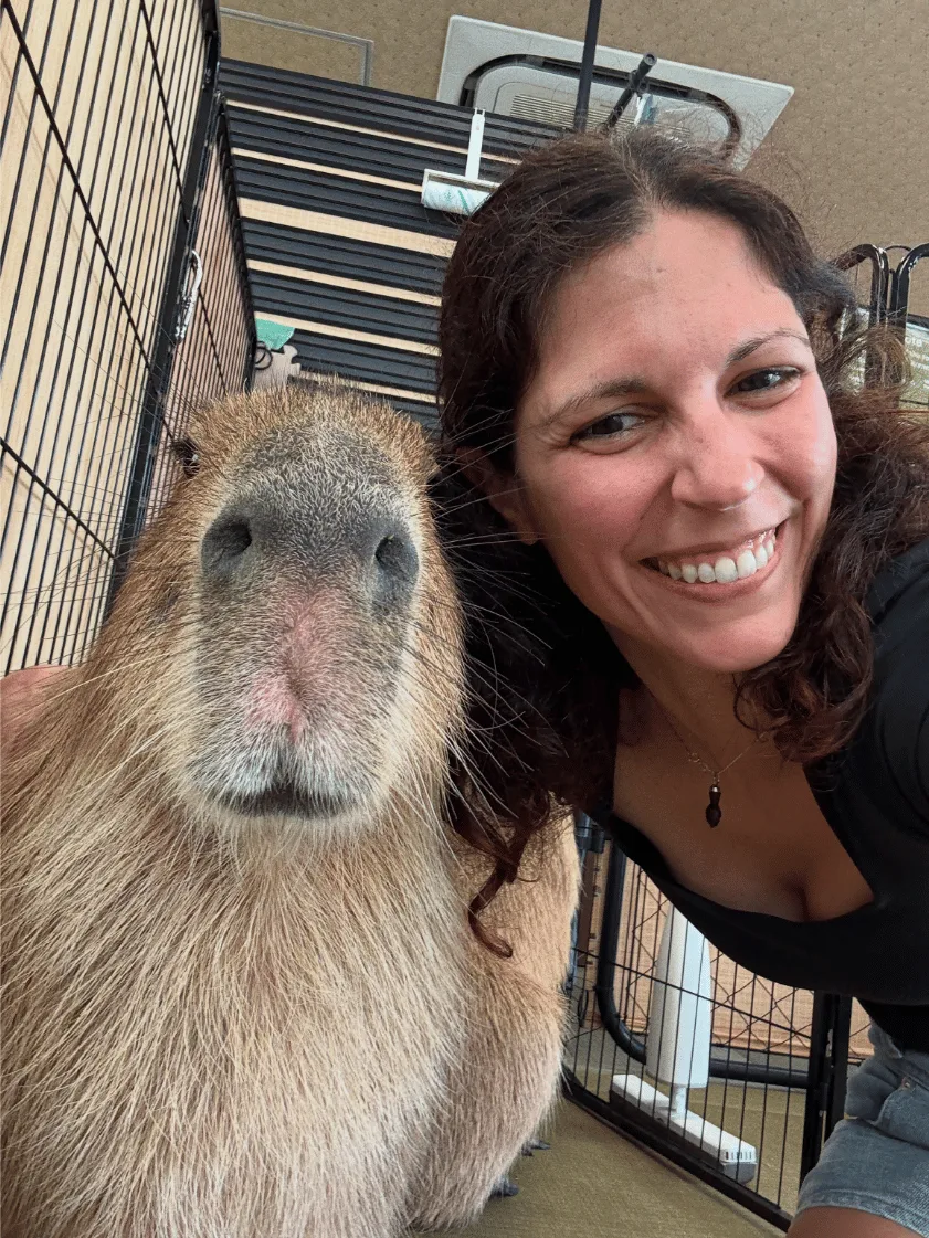 Photo of Adriana taking a selfie with a capybara